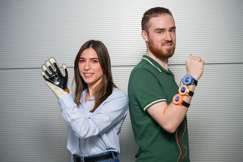 Doktorandin Sipontina Croce und Student Lukas Roth (r.) forschen an Folien, die Textilien neue Fähigkeiten verleihen. Smarte Arbeitshandschuhe werden ebenso möglich wie smarte „Uhren“, die virtuelle Berührungen spürbar machen