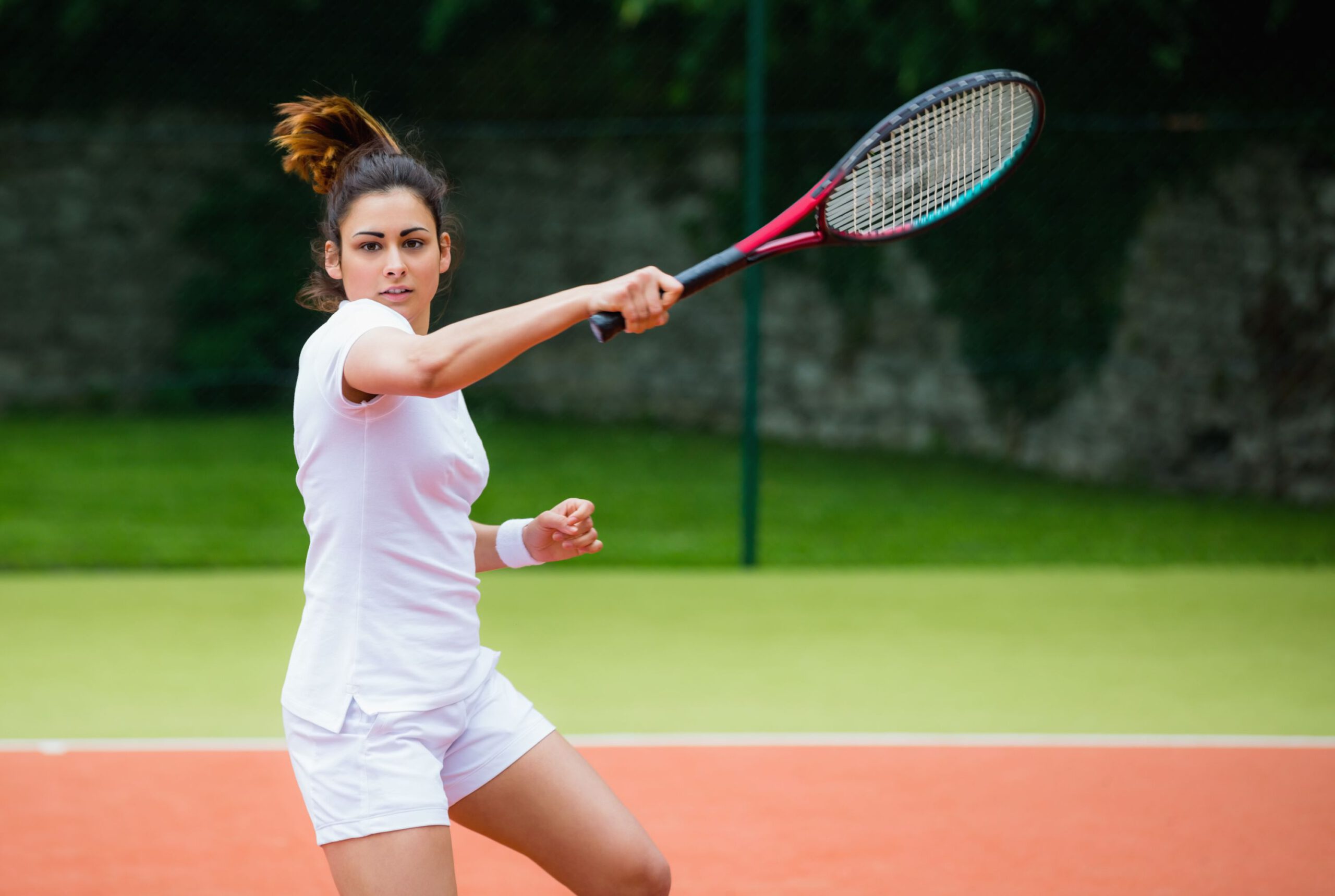 Young tennis player hitting ball