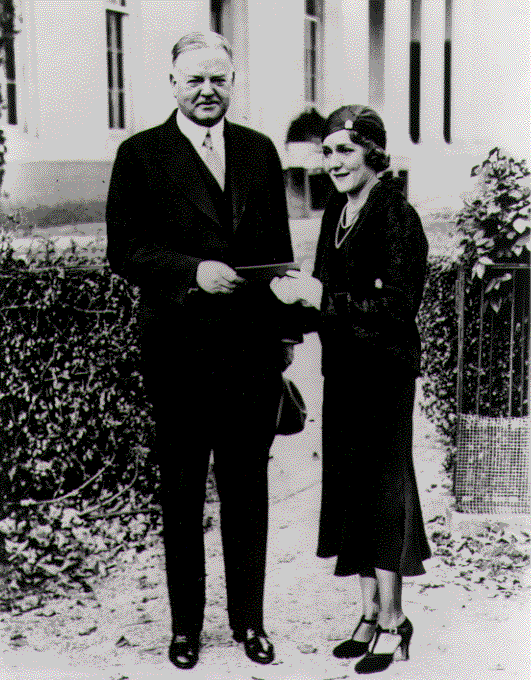 Mary Pickford and H. Hoover in White House grounds, U.S. President Herbert Hoover and film star Mary Pickford. 1931-25A: Mary Pickford gives President Hoover a ticket for a film industry benefit for the unemployed, November 12, 1931. United States Library of Congress's Prints and Photographs division, under the digital ID cph.3a14364 H.E. French, Wikipedia Commons