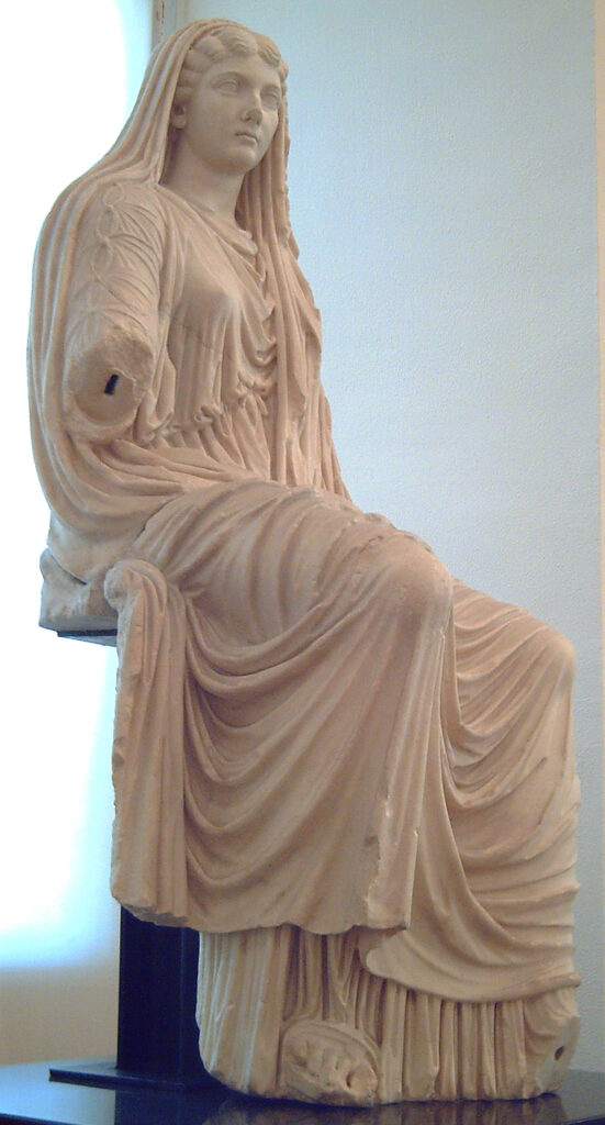 Stola Römische Republik
Überkleid einer römischen Frau. Marmor-Statue einer römischen Frau mit Stola
Von Luis García (Zaqarbal), 14. Mai 2006., Gemeinfrei, https://commons.wikimedia.org/w/index.php?curid=846987
